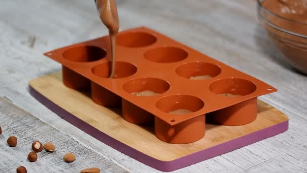 Vrouwelijke handen een siliconen mal vullen met een chocolade mousse. Franse dessert maken. - Video