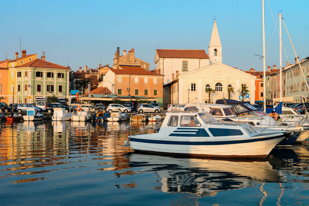 Набережная порта с лодками в Адриатическом море в рыбацком поселке Изола, Словения
 - Фото, изображение