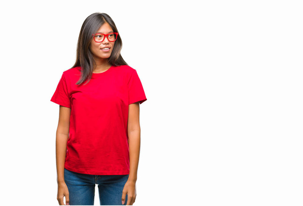 Young asian woman wearing glasses over isolated background looking away to side with smile on face, natural expression. Laughing confident. - Fotografie, Obrázek