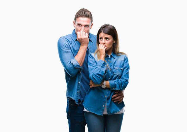 Young couple in love over isolated background looking stressed and nervous with hands on mouth biting nails. Anxiety problem. - Foto, imagen