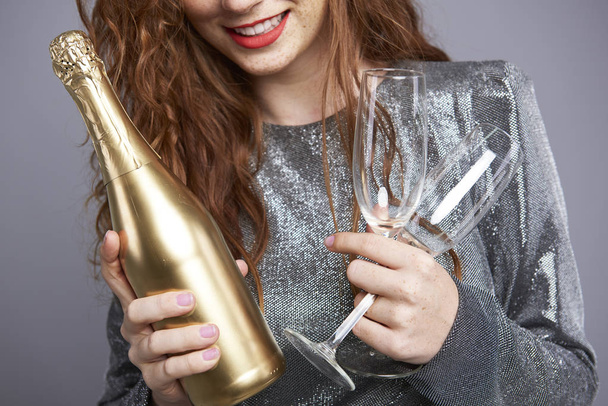 Молодая женщина с шампанским флейтой и бутылкой
 - Фото, изображение