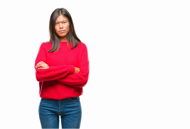 Νεαρά ασιατικές γυναίκα, φορώντας χειμώνα πουλόβερ πάνω από απομονωμένες φόντο σκεπτικιστής και νευρικό, αποδοκιμασίας έκφραση προσώπου με σταυρωμένα τα χέρια. Αρνητικό πρόσωπο. - Φωτογραφία, εικόνα