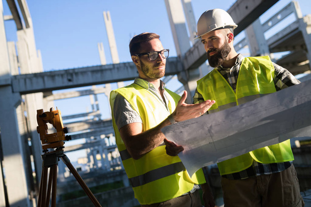 Portrait of construction engineers working on building site together - Φωτογραφία, εικόνα