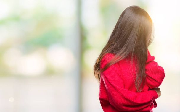 Giovane donna asiatica che indossa maglione invernale su sfondo isolato con espressione triste che copre il viso con le mani mentre piange. Concetto di depressione
. - Foto, immagini