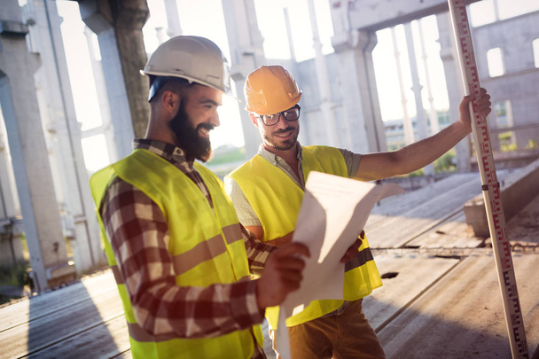 Portrait of construction engineers working on building site together - Φωτογραφία, εικόνα