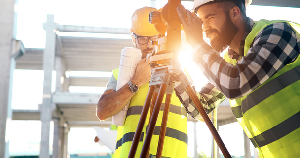 Portrait of construction engineers working on building site together - Fotoğraf, Görsel
