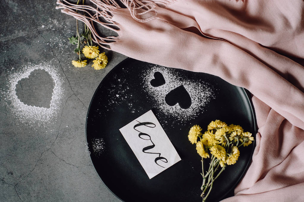 Valentines day.  Scarf, flower and heart on gray table from above in flat lay style. - Fotoğraf, Görsel