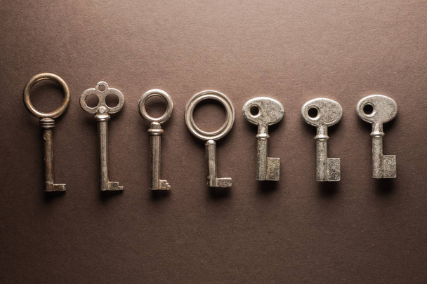 veel verschillende sleutels op bruin tafel - Foto, afbeelding