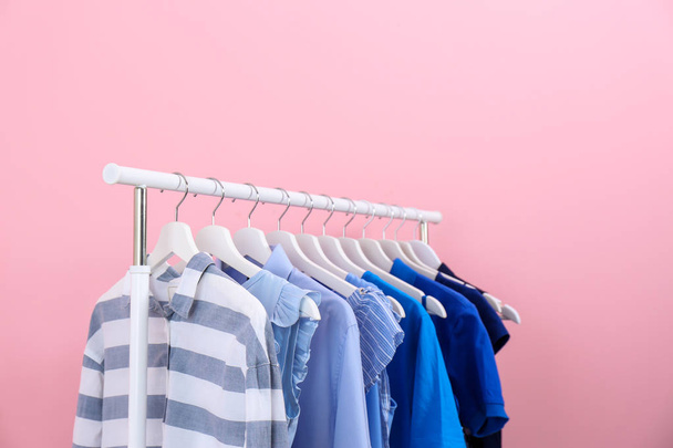 Rack with bright clothes on color background - Fotoğraf, Görsel