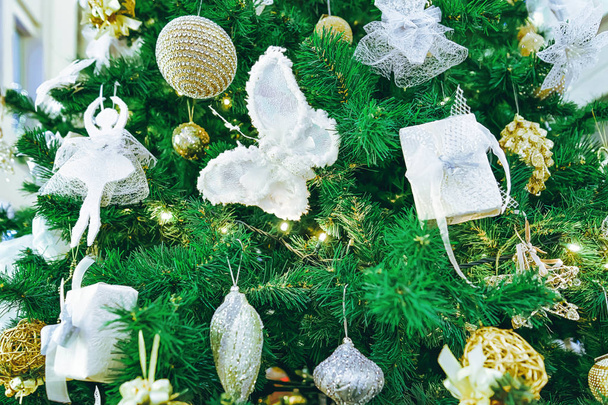 Ángeles, mariposas y otros accesorios como parte de las decoraciones en el árbol de Navidad en los centros Galerija en el mercado de Navidad en invierno Riga en Letonia
. - Foto, imagen
