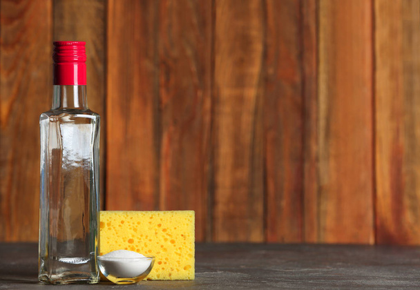 Azijn, bicarbonaat en spons voor het reinigen op tafel. Ruimte voor tekst - Foto, afbeelding