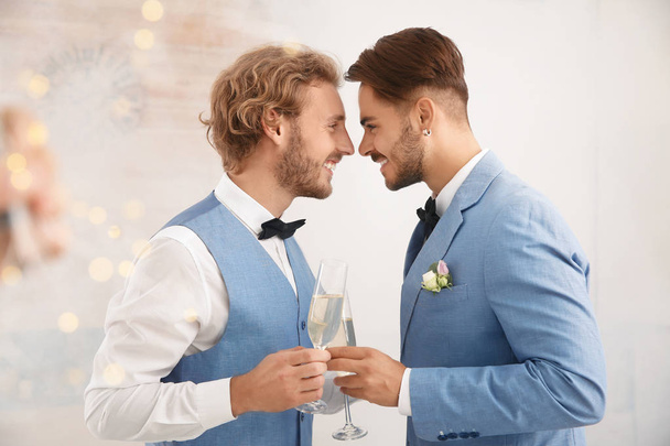 Happy newlywed gay couple with glasses of champagne at home - Photo, Image