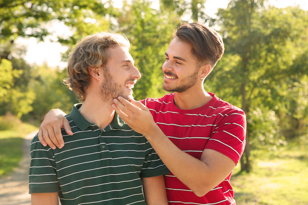 Πορτρέτο του ευτυχισμένο ζευγάρι ομοφυλόφιλων χαμογελά στο πάρκο - Φωτογραφία, εικόνα