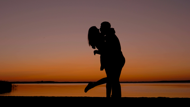 silueta de una pareja amorosa hombres y mujeres besándose y acurrucándose al atardecer
 - Imágenes, Vídeo
