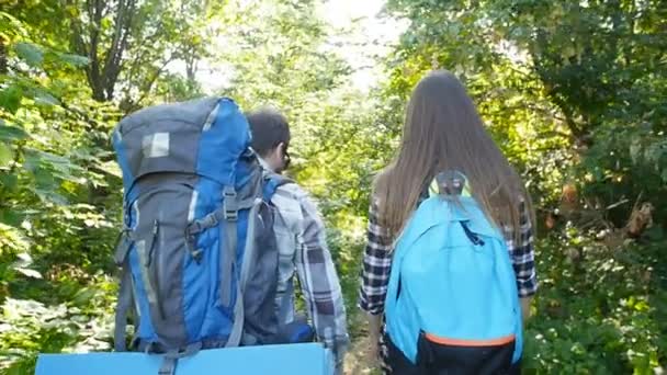 Ormanın içinde sırt çantaları ile genç çift. Seyahat ve kavram Hiking - Video, Çekim