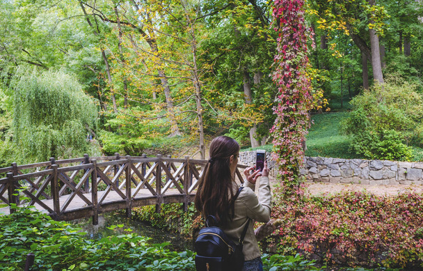 tyttö ottaa puhelimen kaunis maisema puistossa
 - Valokuva, kuva
