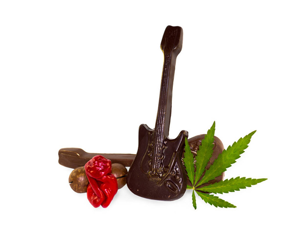 Idea concept background of Sex, drugs, rock and roll. Chilli Willy pepper as sex, chocolate as rock music and hemp leaf as drug on white background. The ideals of modern subculture - Photo, Image