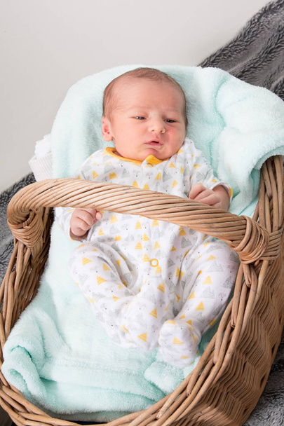 Niño bebé recién nacido acostado durmiendo en una cesta de madera para la fotografía
 - Foto, Imagen