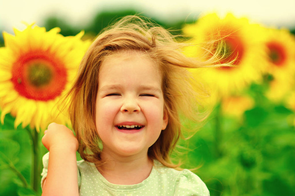 Χαμογελαστό κορίτσι στο πεδίο ηλιοτρόπια  - Φωτογραφία, εικόνα