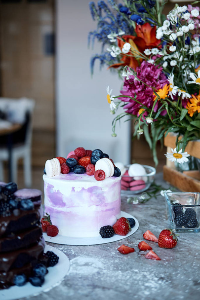 Holiday cake. Sweet desserts with berries and macarons. Cake from the fruit. Delicious sponge cake - Fotoğraf, Görsel