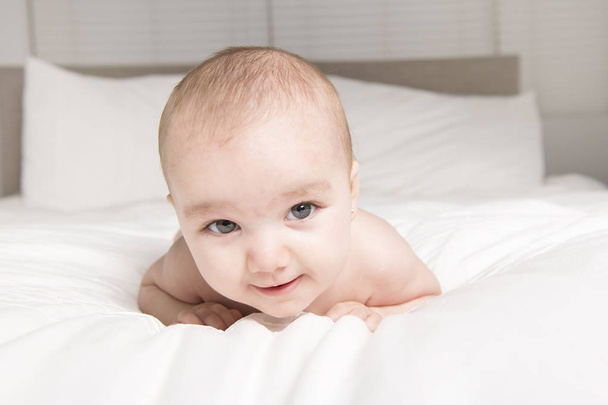 Cute little baby on the white bed - Foto, Imagem