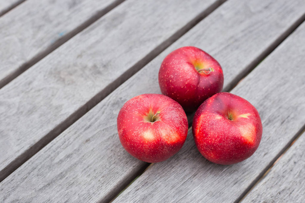Органические свежие яблоки на деревянном фоне. Концепция сельского хозяйства со свежими яблоками в природе - Фото, изображение