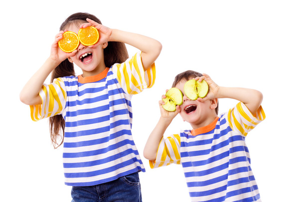 Two funny kids with fruits on eyes - 写真・画像