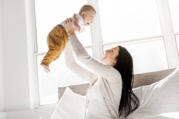 Mother with a baby on bed at home - Foto, imagen