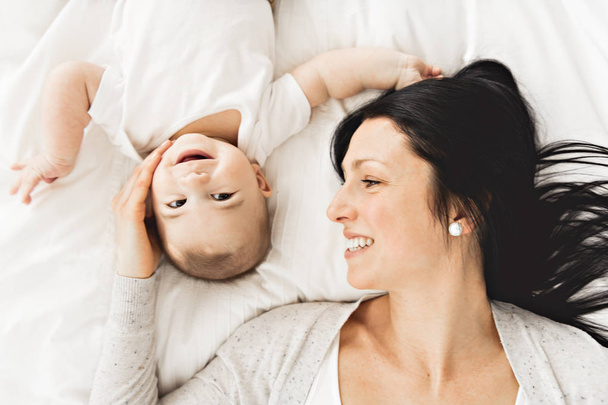 Mother with a baby on bed at home - Foto, Imagen