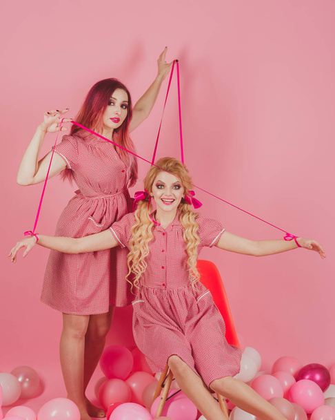 retro girls in party balloons. Creative idea. Funny advertising. Crazy girl on pink. Halloween. vintage fashion women puppet. holidays and dolls. Going crazy together. Crazy idea. Crazy advertising - Фото, зображення