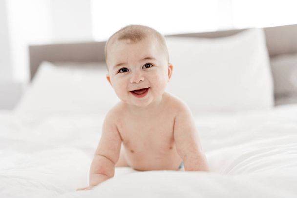 Portrait of a baby boy on the bed in bedroom - Foto, afbeelding