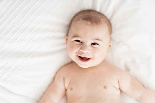 Portrait of a baby boy on the bed in bedroom - Фото, зображення