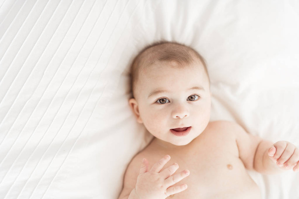 Portrait of a baby boy on the bed in bedroom - Photo, Image
