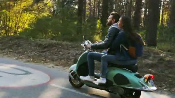 glückliches Paar auf einem Motorroller im Wald. sonniger schöner Tag. - Filmmaterial, Video