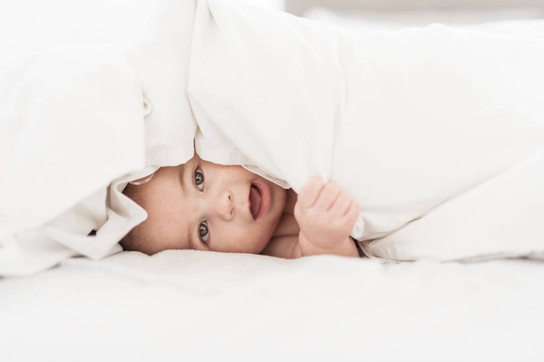 Portrait of a baby boy on the bed in bedroom - Photo, image