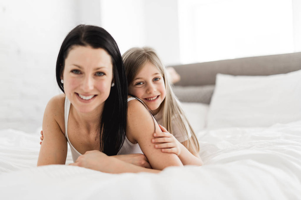 Mother and daughter enjoy in bed at home - Fotografie, Obrázek