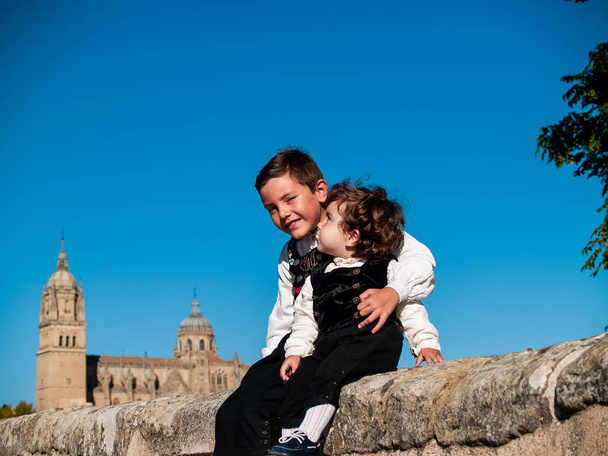 Dvě děti bratři přijali na římský most v Salamance, oblečen v tradičním oblečení a katedrála v Salamance - Fotografie, Obrázek
