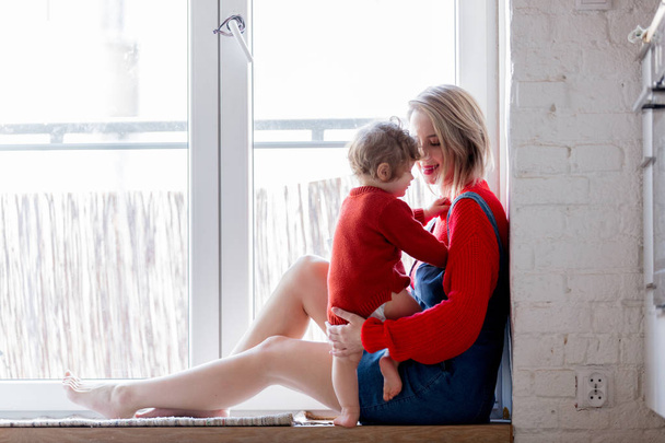 girl with a toddler boy is sitting at the threshold - Foto, Imagen