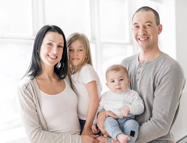 Family of four on a beautiful room with white window - Fotoğraf, Görsel