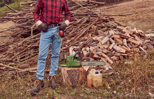 Testere ile kesme woods yığını ile oduncu. - Fotoğraf, Görsel