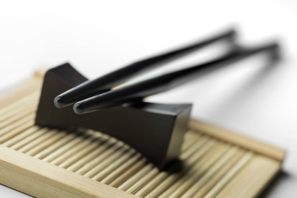 Black chopsticks for rice on a white background - Photo, Image