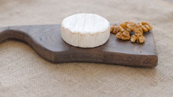 Bílá plíseň sýr otočit na dřevěném prkénku - Záběry, video