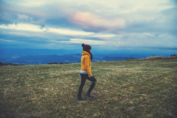 Mujer caminando en un prado de montaña vacío
. - Foto, imagen