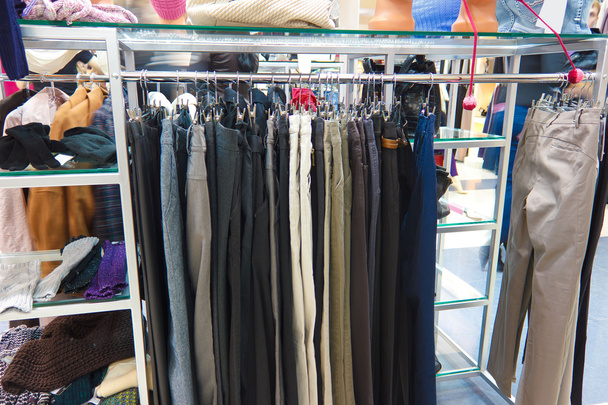 shop pants different group colored jeans hanging on a hanger in - Photo, Image