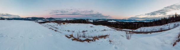 Evening twilight winter snow covered alp Gorgany, Chornohora and Svydovets mountain ridges (Ukraine, Carpathian Mountains, scenery panorama view from Yablunytsia pass). Car model unrecognizable. - 写真・画像