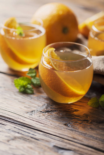 Zimna herbata z orange i mint na drewnianym stole, Selektywny fokus - Zdjęcie, obraz
