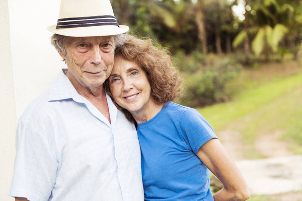 Portrait of a beautiful elderly couple standing embracing outdoors - Foto, Imagen