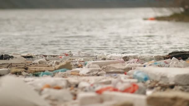 Müll treibt in Ufernähe im Wasser. - Filmmaterial, Video