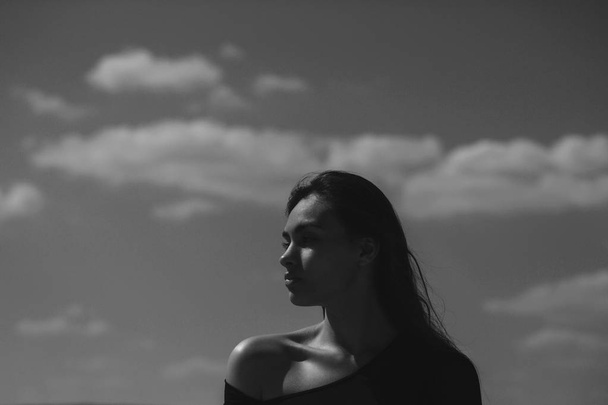 woman posing in black top on blue sky - 写真・画像