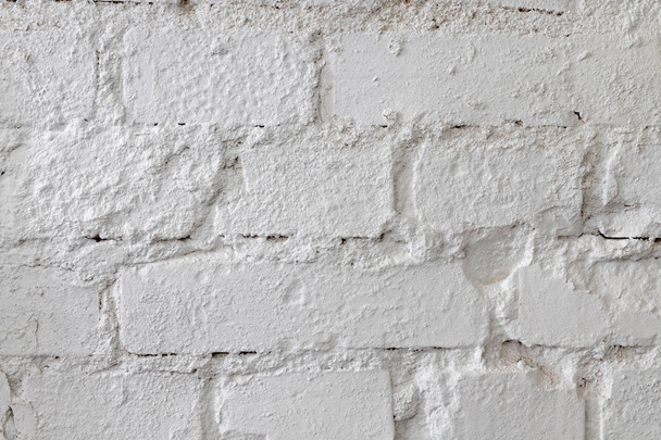 Mur de briques blanches. Un vieux mur de briques peint avec de la peinture et complété par du plâtre. Fond clair
. - Photo, image
